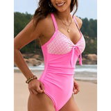 Beach Babes pink sexy one-piece bathing suit with patterned bust and front tie detail on beach