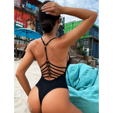 Beach Babes sexy v-neck one-piece swimsuit in black with strappy open back design at the beach