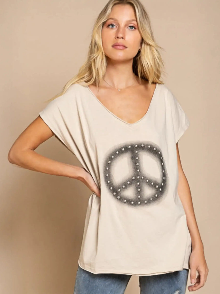Woman trying on Chic V-neck Beige Tee with peace sign in fitting room