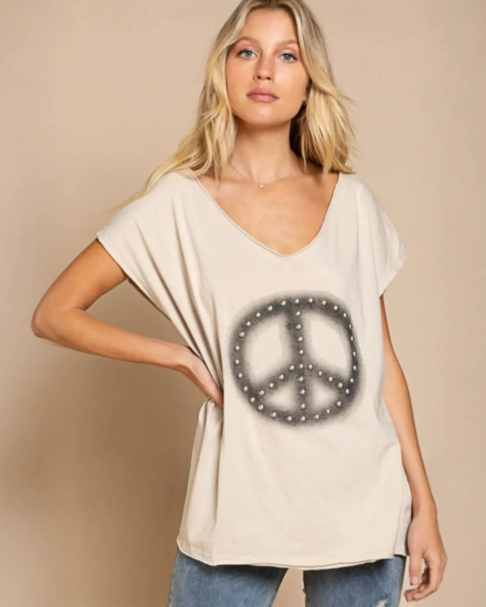 Woman trying on Chic V-neck Beige Tee with peace sign in fitting room