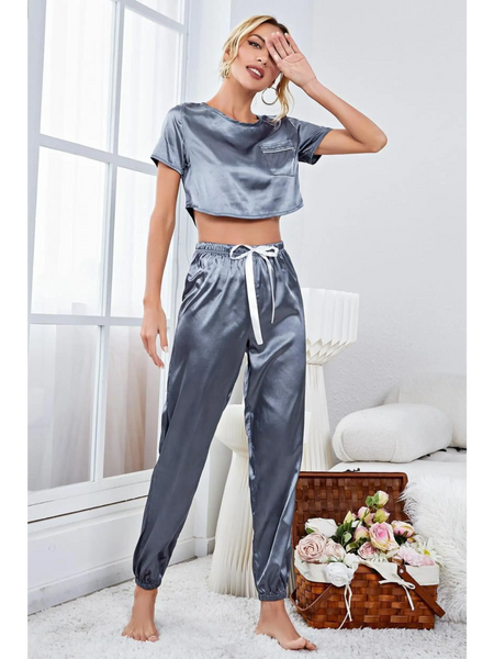 Gray silky lightweight crop top and joggers set by Babe Beachwear modeled indoors near window and floral basket