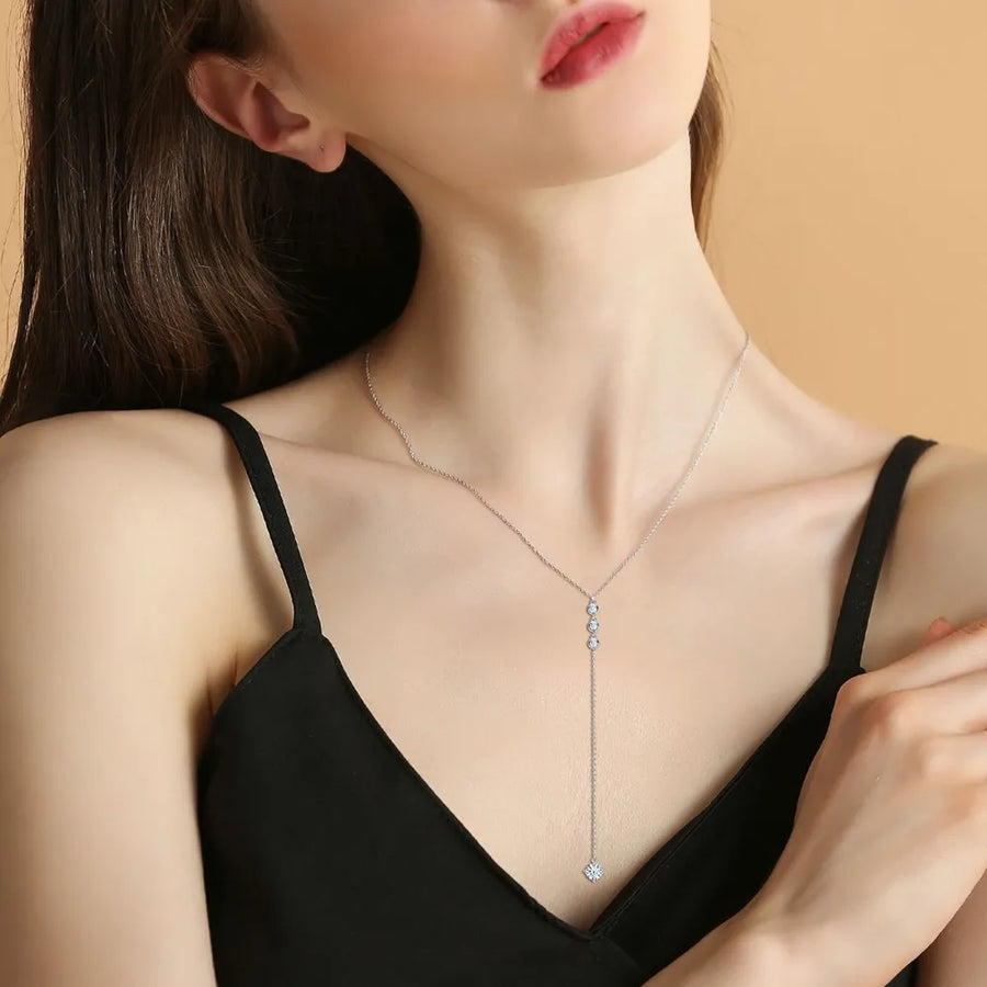 Elegant 1.3 carat drop necklace worn by woman in black dress featuring delicate silver chain and sparkling pendant