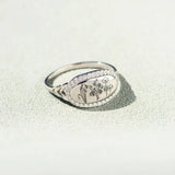  women's summer statement ring with oval floral design and silver band on textured surface