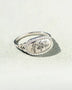  women's summer statement ring with oval floral design and silver band on textured surface