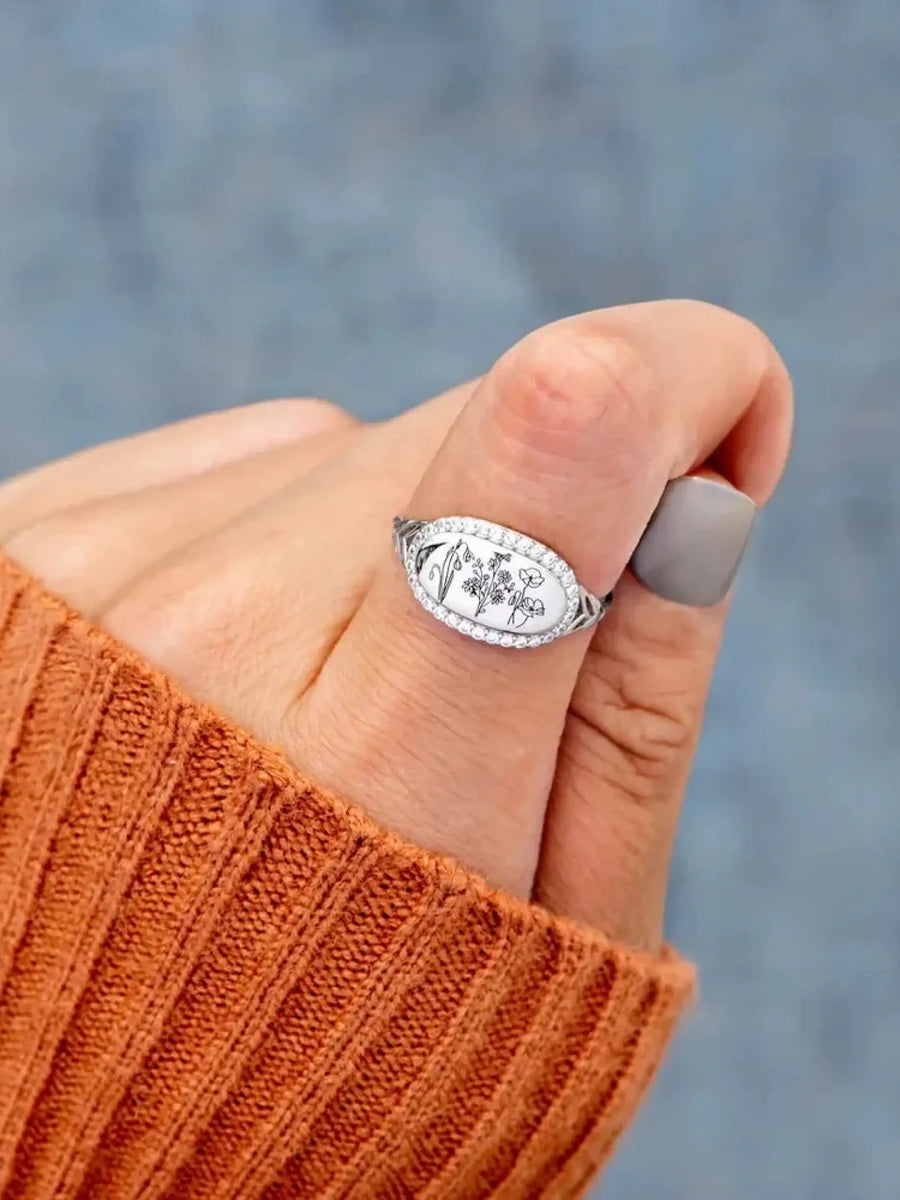  women's summer statement ring with floral design worn on thumb with orange sweater