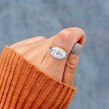  women's summer statement ring with floral design worn on thumb with orange sweater