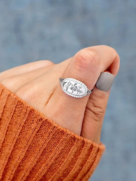  women's summer statement ring with floral design worn on thumb with orange sweater