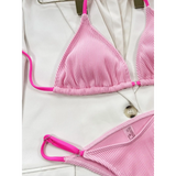 Beach Babes pink ribbed skimpy neon bikini set with adjustable straps laid on white fabric