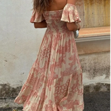 Trendsi smocked off shoulder midi dress with pink floral patterns and ruffled hem on model