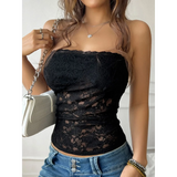 Babe Beachwear black strapless lace crop top worn with blue jeans and a white handbag
