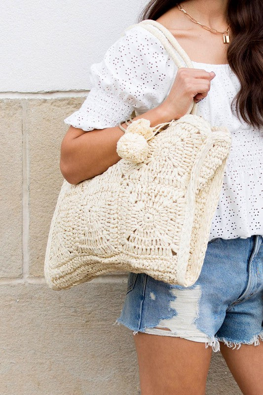 Babe Beachwaer Straw Summer Tote bag in beige woven design carried by woman in white top and denim shorts