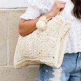 Babe Beachwaer Straw Summer Tote bag in beige woven design carried by woman in white top and denim shorts