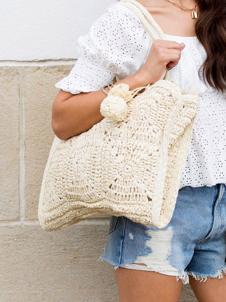Babe Beachwaer Straw Summer Tote bag in beige woven design carried by woman in white top and denim shorts