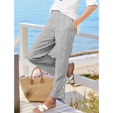 Striped beach pants for women by Babe Beachwear styled with white shirt and sandals near the ocean