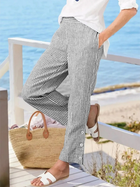 Striped beach pants for women by Babe Beachwear styled with white shirt and sandals near the ocean