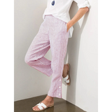 Striped beach pants for women in white and red with side buttons paired with white shirt and sandals
