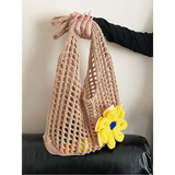 Babe Beachwear summer crochet tote 2025 in beige with a yellow flower held by hand