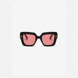 Black-framed sunglasses with pink lenses for beach vacations and cool beach styles