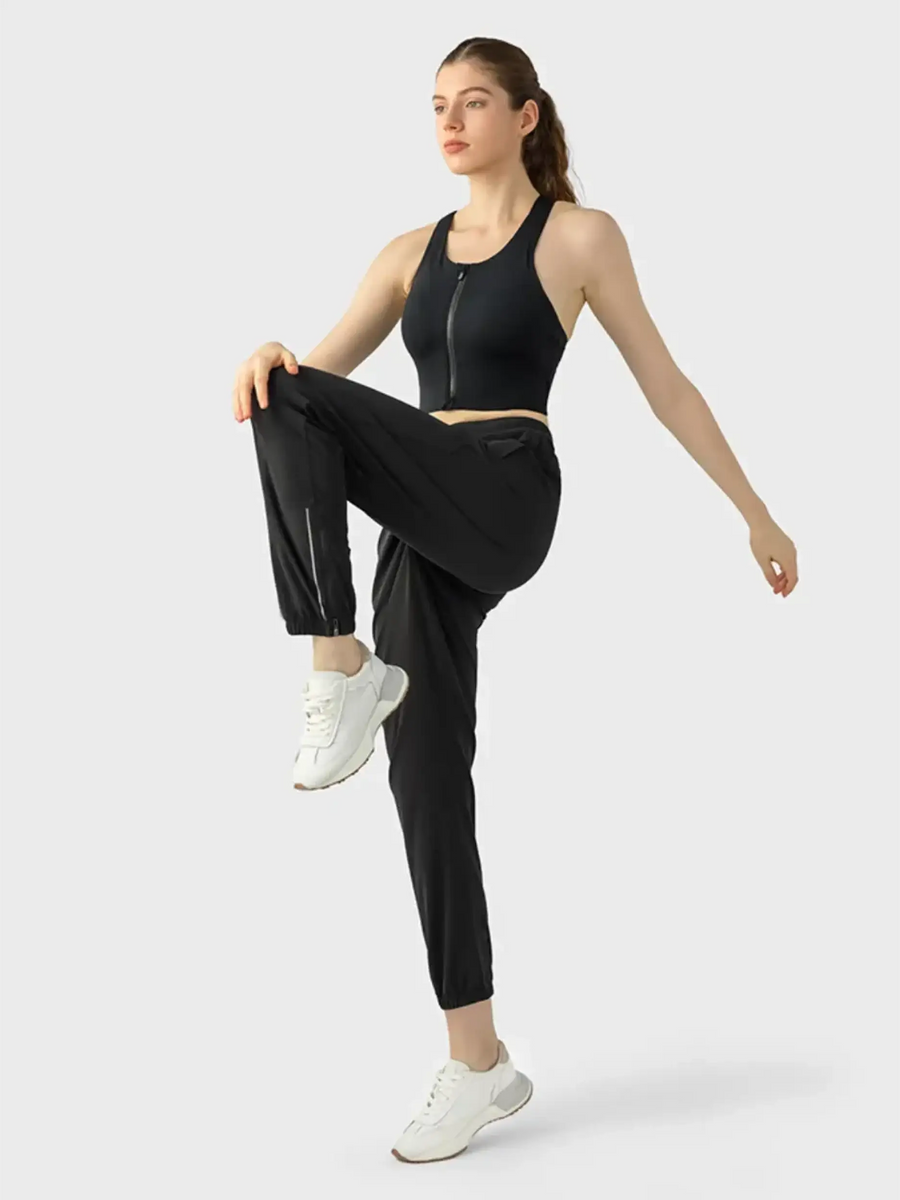 Trendsi black zip front sports bra worn by woman in active pose supportive workout bra for women