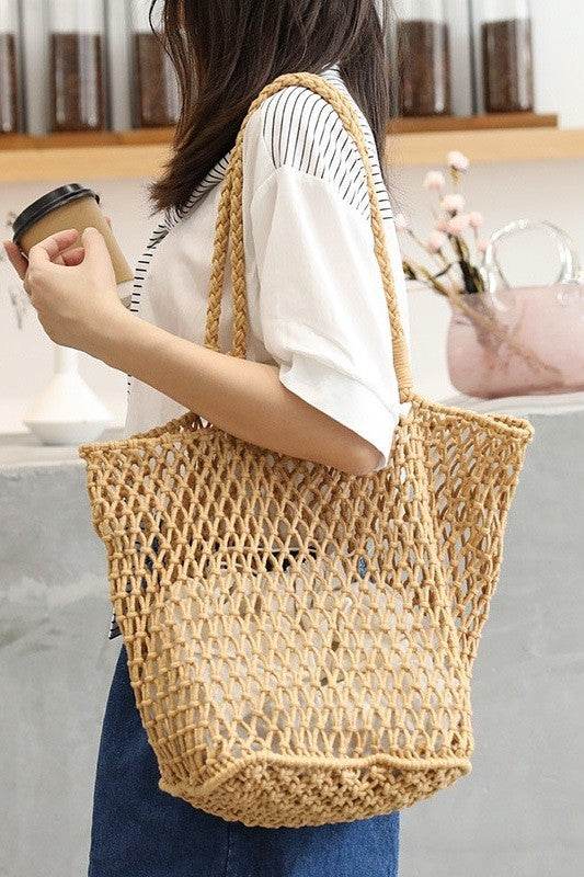 Miss Sparkling braided net beach tote in natural color worn by woman holding a coffee cup