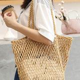 Miss Sparkling braided net beach tote in natural color worn by woman holding a coffee cup