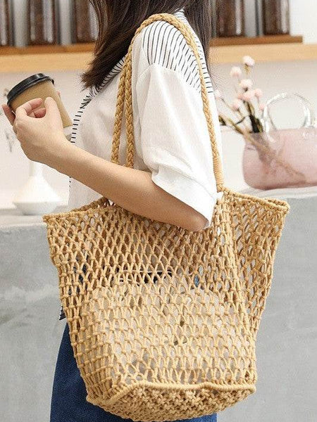 Miss Sparkling braided net beach tote in natural color worn by woman holding a coffee cup