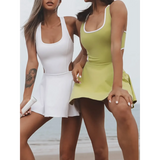 Trendsi Criss Cross Cutout Tennis Skort Dress in white and green worn by two women on beach