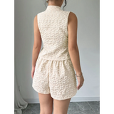 Back view of textured resort vest and short set in cream color from Trendsi