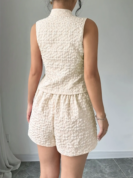 Back view of textured resort vest and short set in cream color from Trendsi