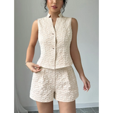 Textured resort vest and short set in cream featuring sleeveless button-up vest and high-waist shorts