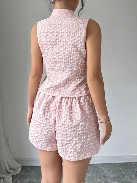 Back view of a woman wearing a pink textured resort vest and short set by Trendsi