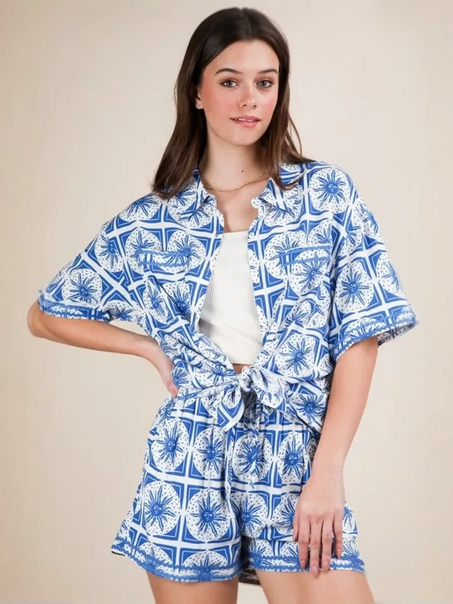 Woman wearing Babe Beachwear tropical blue shorts set with patterned button-up shirt and matching shorts