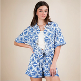 Woman wearing Babe Beachwear tropical blue shorts set with patterned button-up shirt and matching shorts