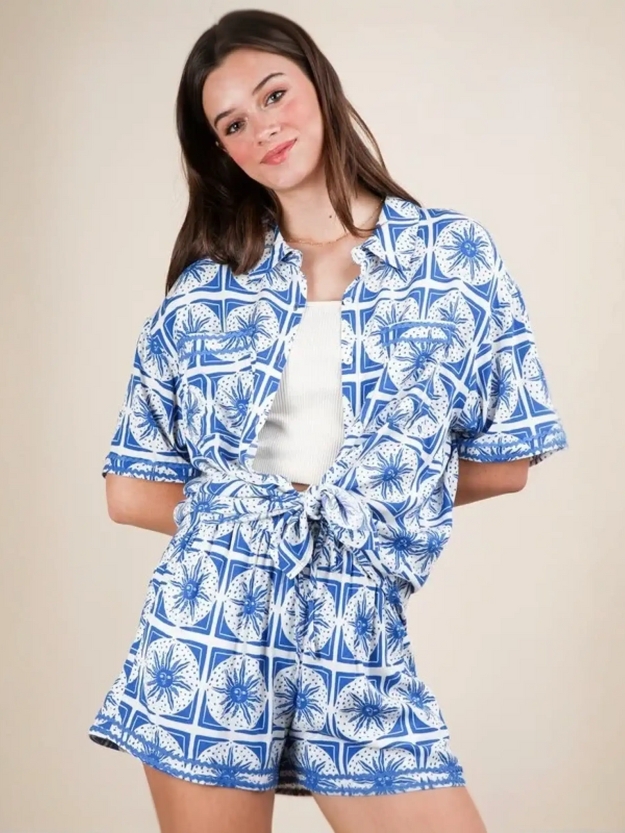Woman wearing Babe Beachwear tropical blue shorts set featuring a patterned short-sleeve top and matching shorts