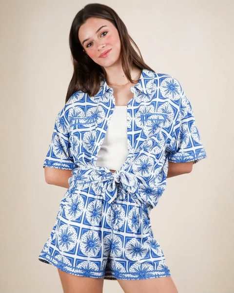 Woman wearing Babe Beachwear tropical blue shorts set featuring a patterned short-sleeve top and matching shorts