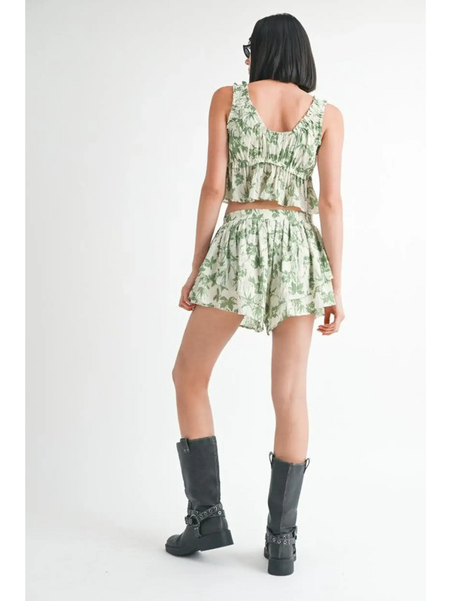 Back view of woman wearing Emory Park Tropical Green Floral Tank Top with matching shorts and black boots