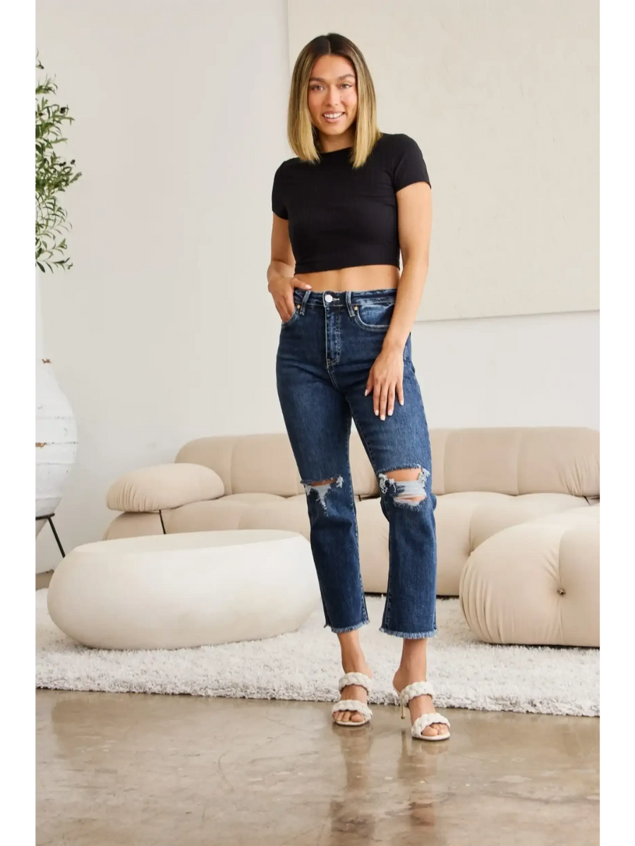 Trendsi tummy control high waist jeans in dark wash with distressed knees worn by woman indoors