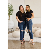 Two women wearing Trendsi tummy control high waist jeans with ripped knees paired with black tops indoors