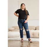 Trendsi tummy control high waist jeans in dark blue with distressed knees worn by woman with black top and heels