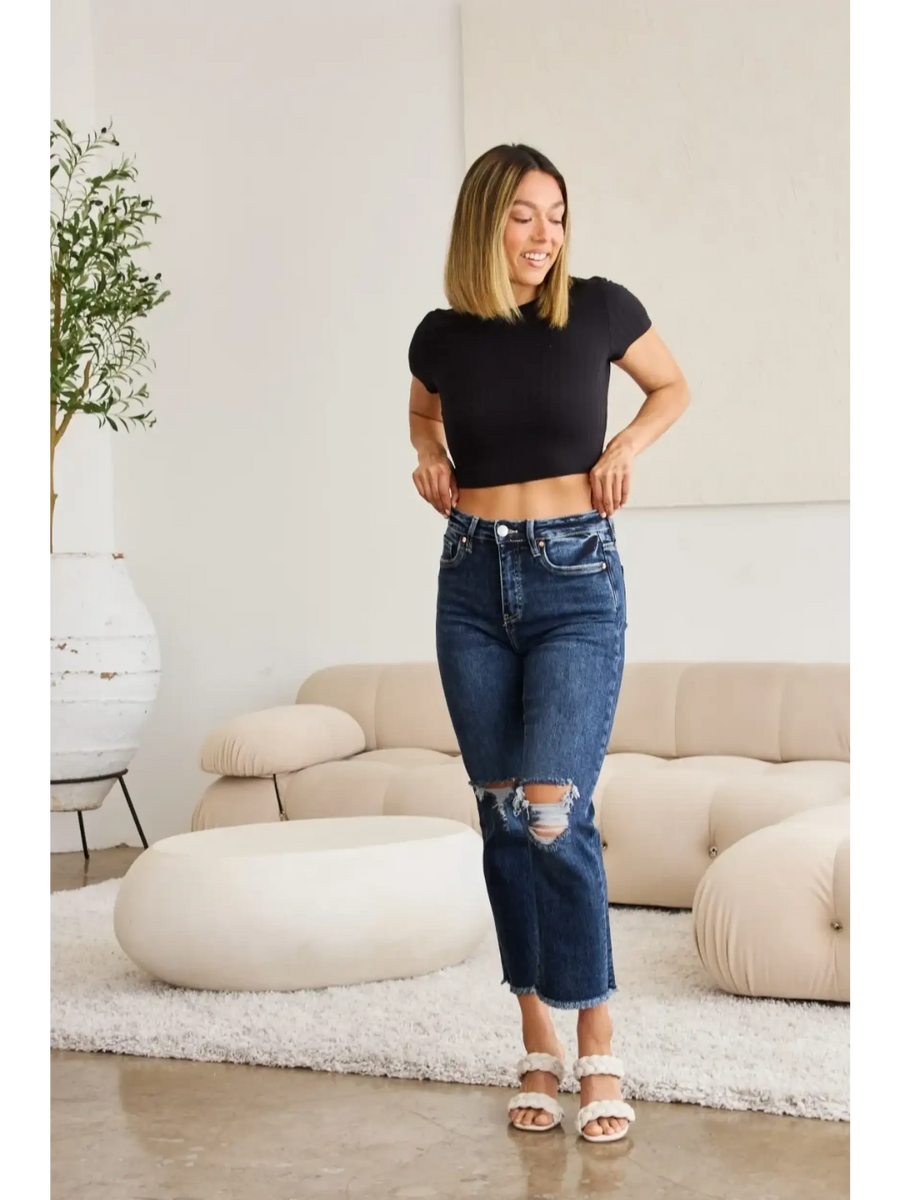 Woman wearing Trendsi tummy control high waist jeans with distressed knees and a black crop top