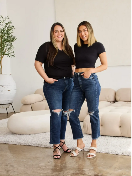 Two women wearing Trendsi tummy control high waist jeans with ripped knees and black tops in modern living room