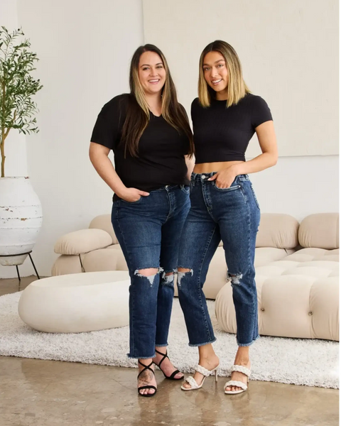 Two women wearing Trendsi tummy control high waist jeans with ripped knees and black tops in modern living room