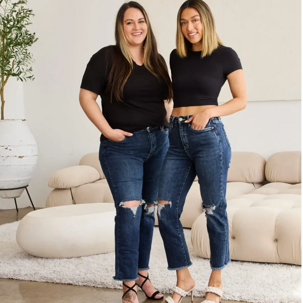 Two women wearing Trendsi tummy control high waist jeans with ripped knees and black tops in modern living room