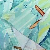 Close-up of turquoise turtle beach dress fabric details by Babe Beachwaer with stitching and vibrant tropical print