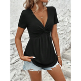 Babe Beachwear black twisted front v-neck t-shirt for women styled with denim shorts against a textured white wall