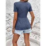 Back view of a woman wearing a navy twisted front v neck t shirt for women paired with light denim shorts