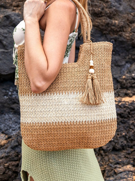 Babe Beachwear two tone straw tote bag with tassel detail carried by woman in green skirt