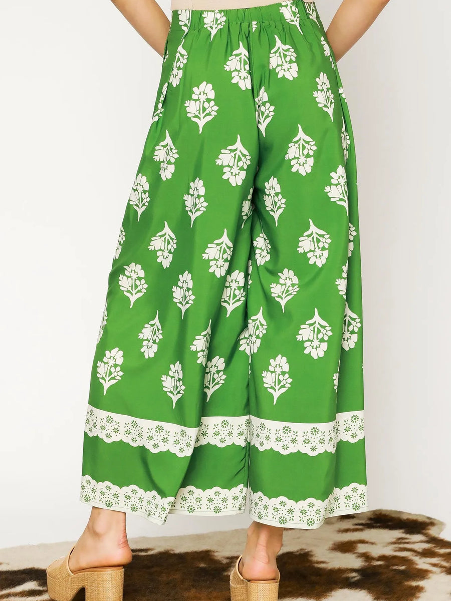 green wide leg pants featuring Umgee floral palazzo pants design with white floral print and lace trim