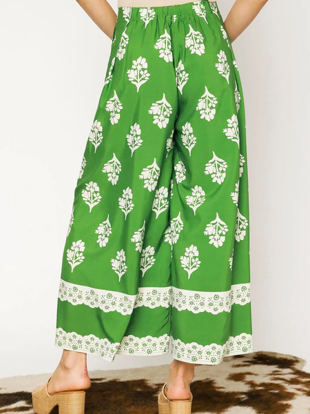 green wide leg pants featuring Umgee floral palazzo pants design with white floral print and lace trim