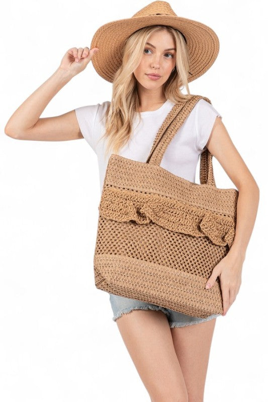 Artini Accessories uniqe ruffle straw bag held by woman in white shirt and denim shorts with straw hat
